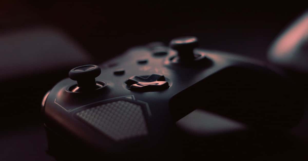 A close-up shot of a game controller in low light, highlighting its design and buttons.