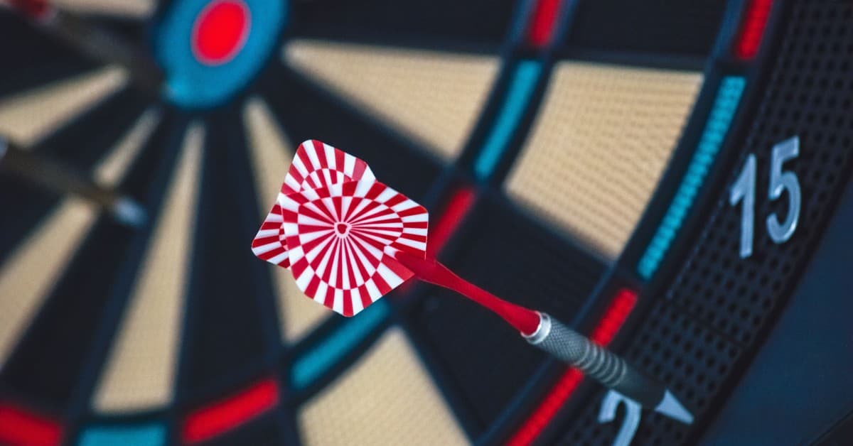 A dart striking the bullseye on a dartboard, showcasing precision and accuracy.