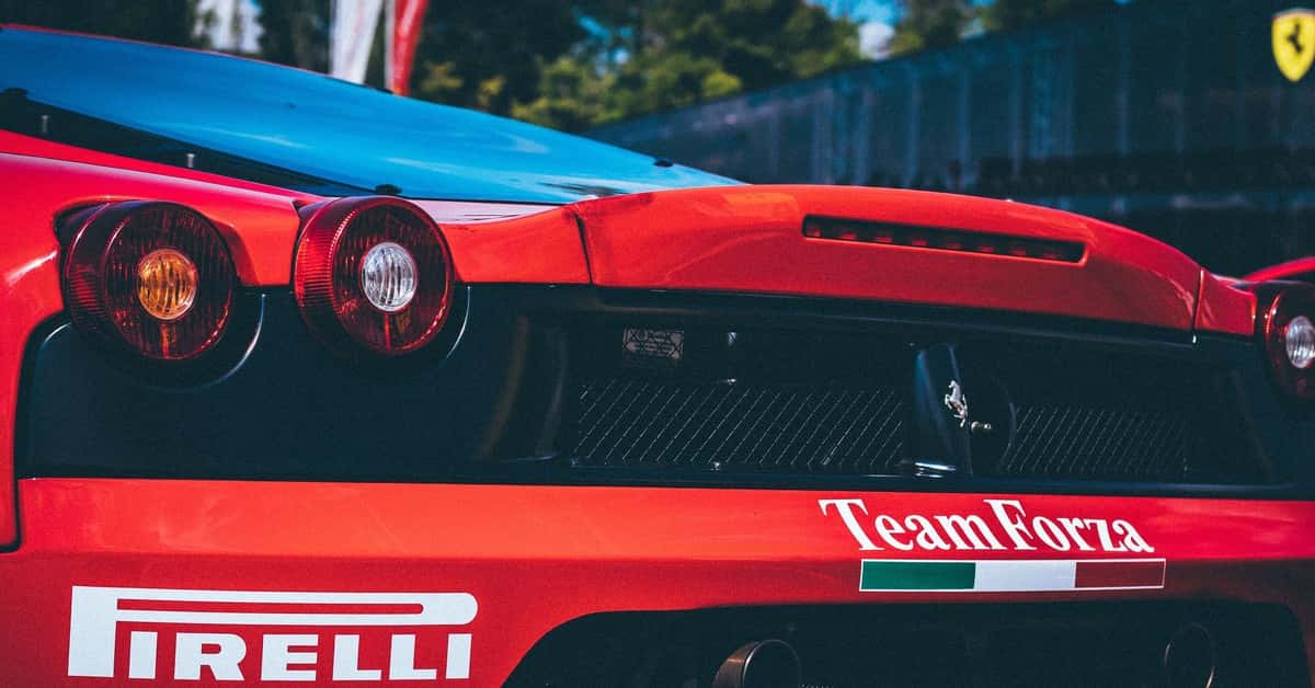 Racing car with Pirelli branding, featuring aerodynamic rear designs. Captured in daylight outdoors.