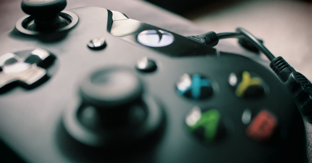 Detailed view of a black gaming controller showcasing its sleek design and colorful buttons.