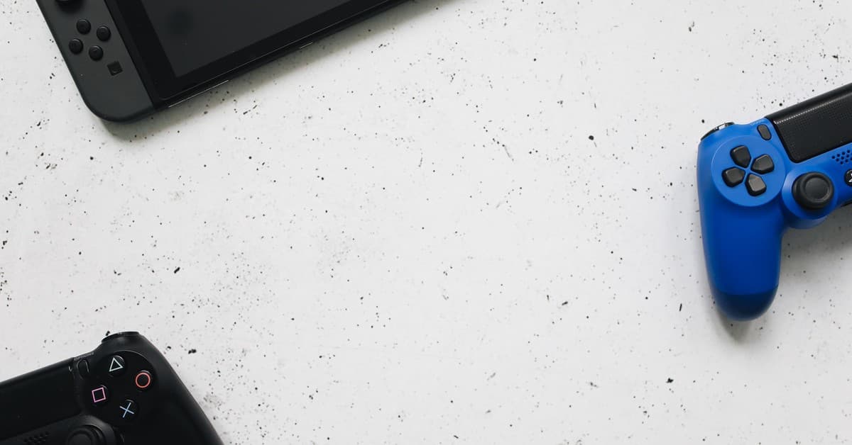 A flat lay of gaming consoles and controllers on a white surface, ideal for tech enthusiasts.