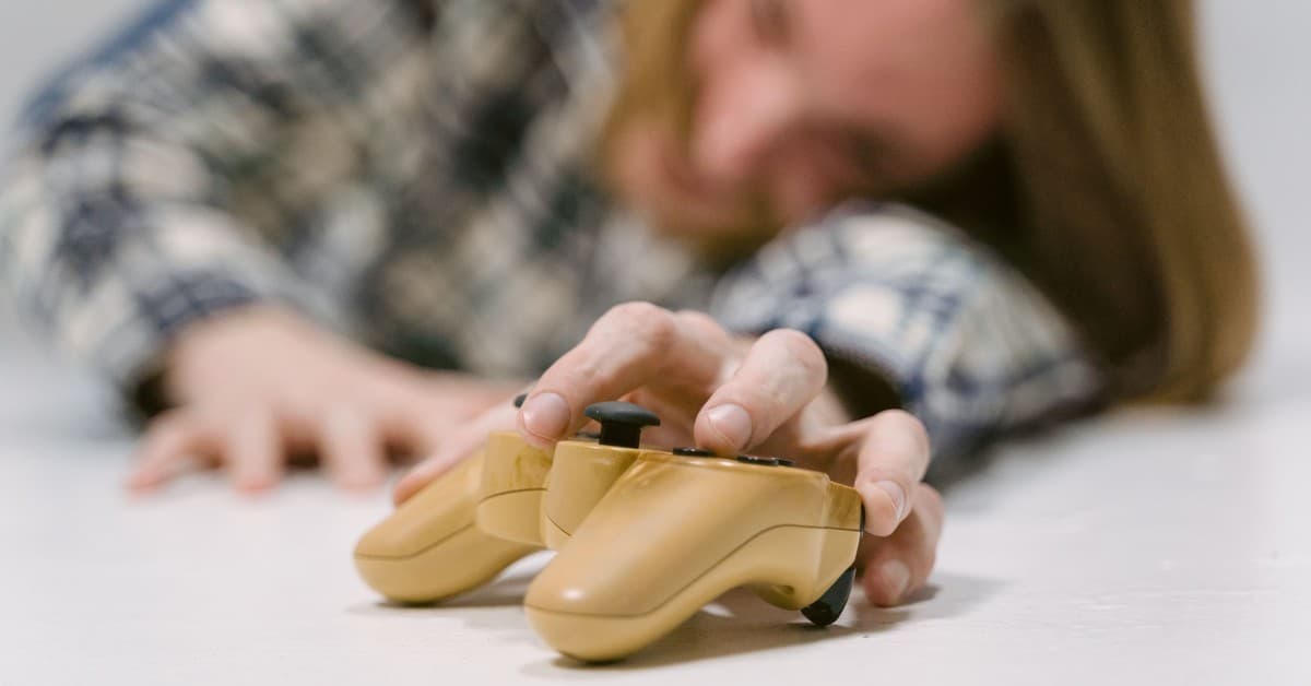 Hand reaching out to touch a yellow game controller, focus on interaction.