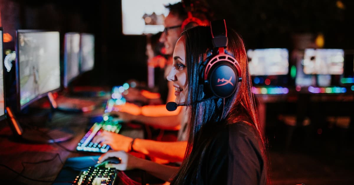 People enjoying a late-night video gaming session with headsets and RGB keyboards.