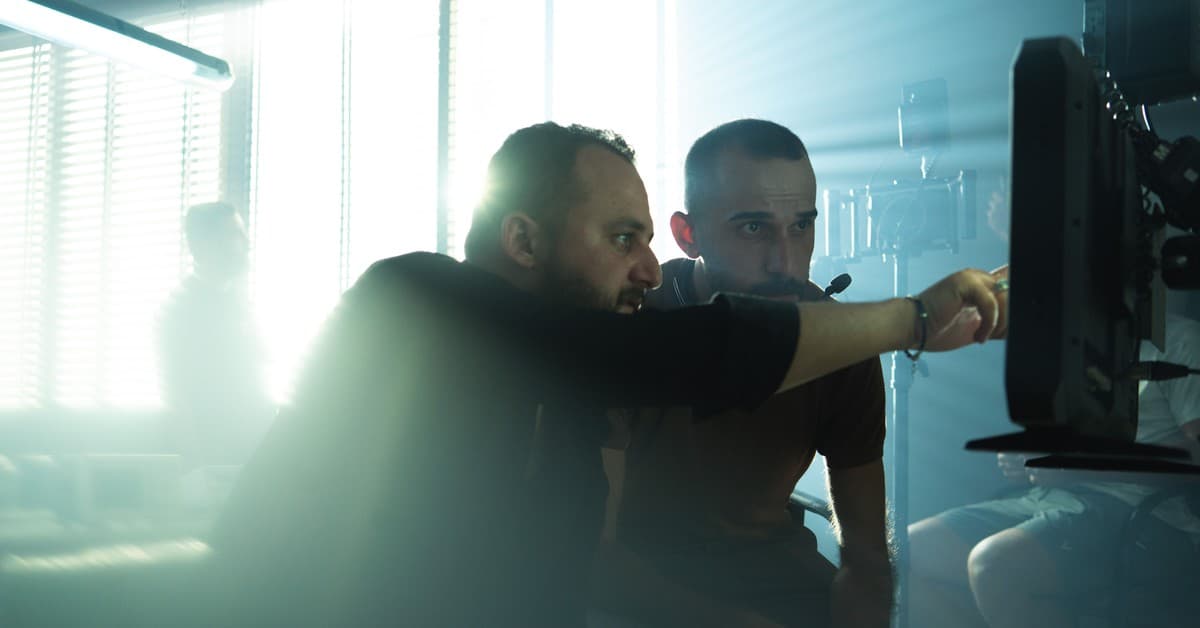 Film crew collaborating on set with cinematic lighting in Baghdad, Iraq, showcasing teamwork and creativity.