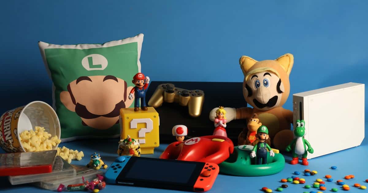 A vibrant assortment of gaming collectibles, including Nintendo figures, consoles, and candy on a blue background.