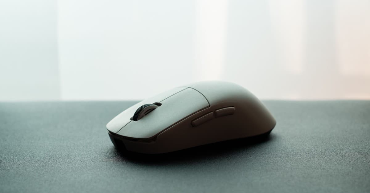 Close-up of a white wireless computer mouse on a dark surface, emphasizing sleek design.