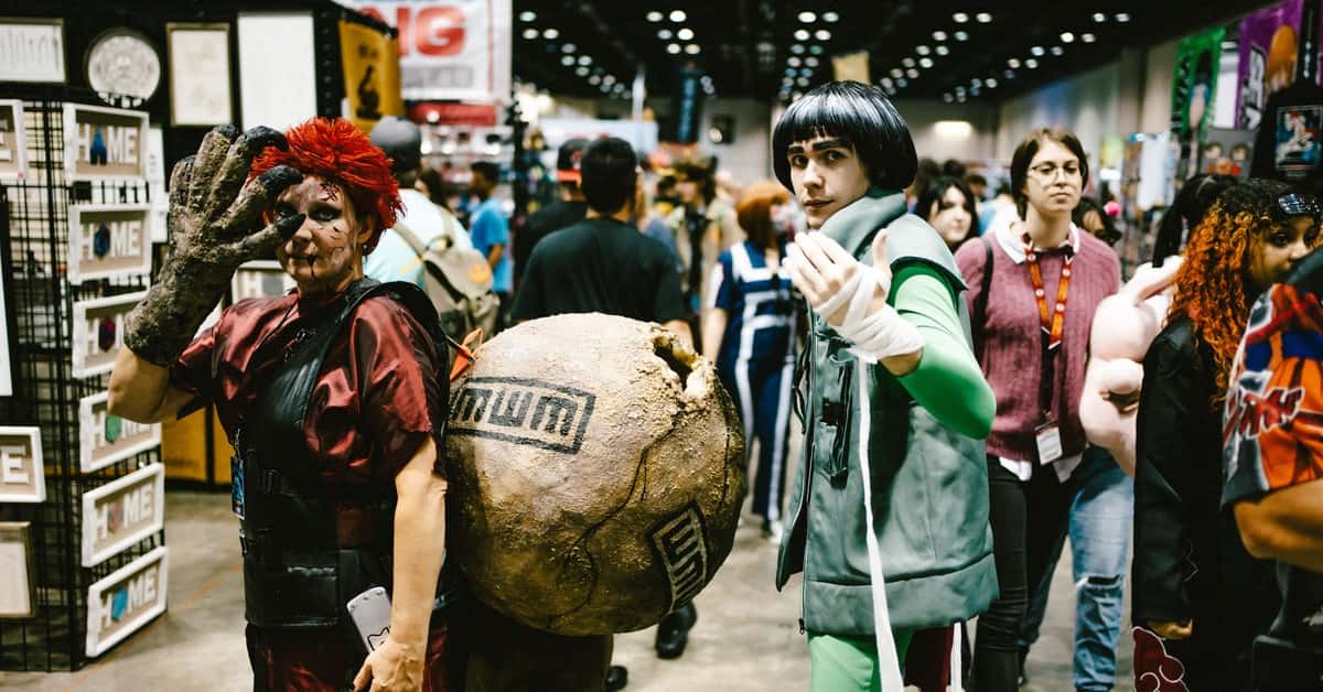 Cosplayers dressed as anime characters at a bustling convention center.