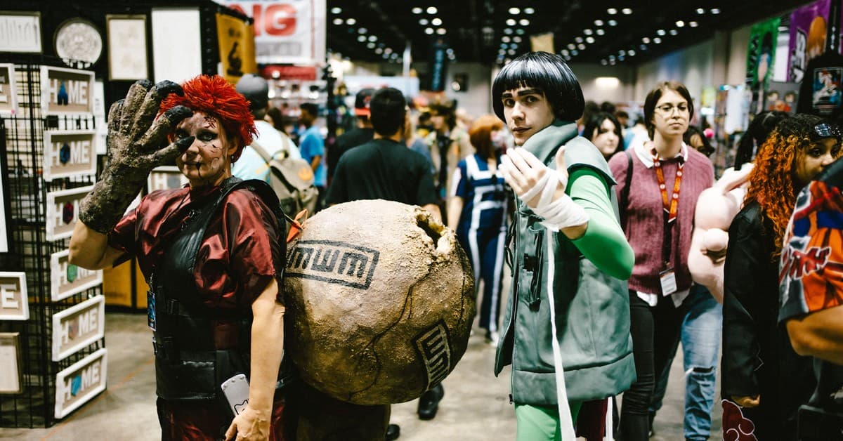 Cosplayers dressed as anime characters at a bustling convention center.