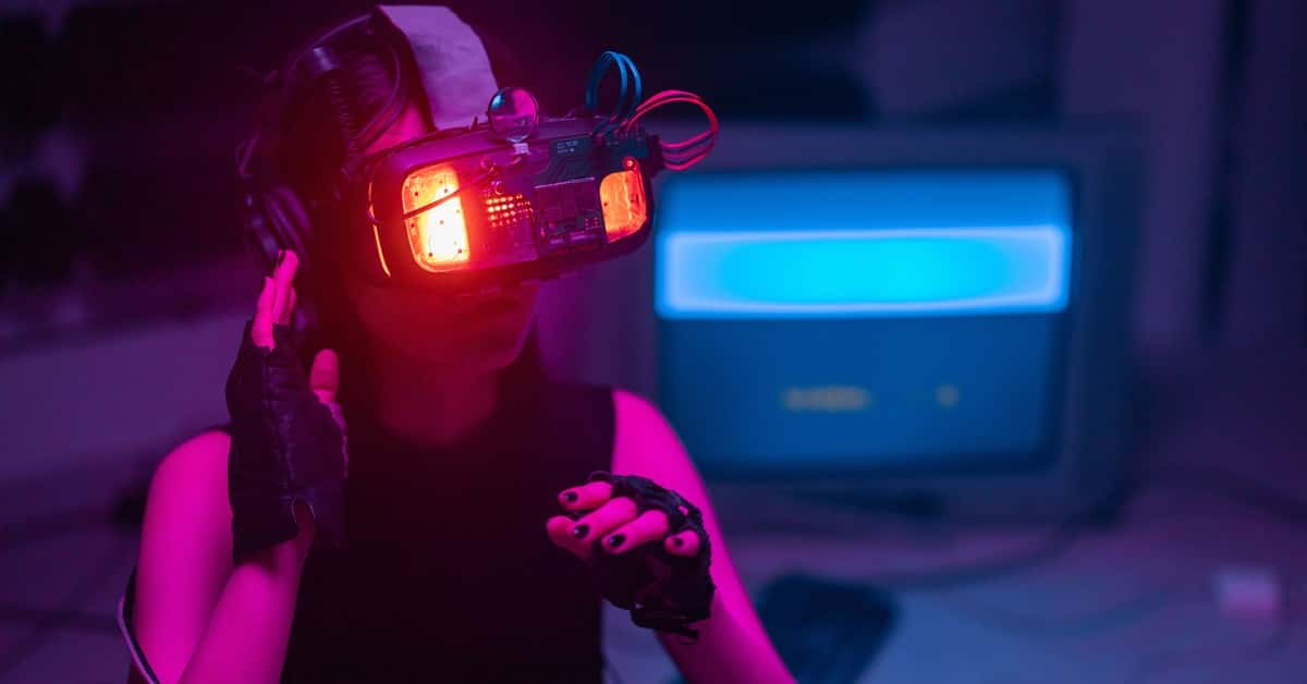 A woman immerses in virtual reality with neon-lit goggles and gloves in a tech-savvy environment.