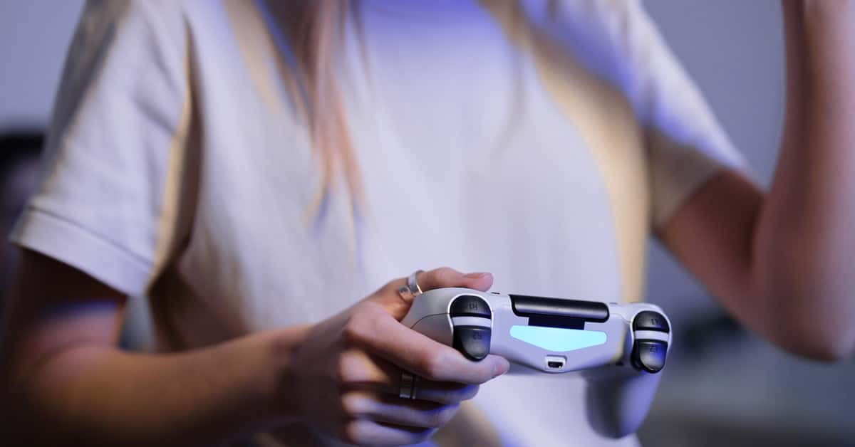 Person playing video games with game controller in a relaxed setting.
