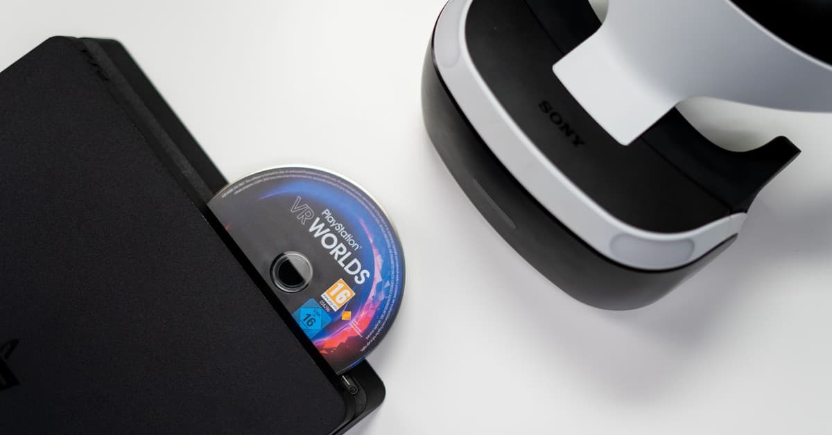 Overhead view of PlayStation console, VR headset, and game disc on a white background.