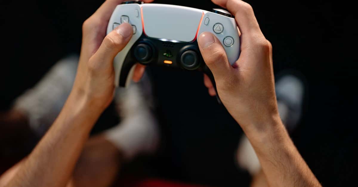 Hands gripping a modern game controller, ready for immersive gaming experience.
