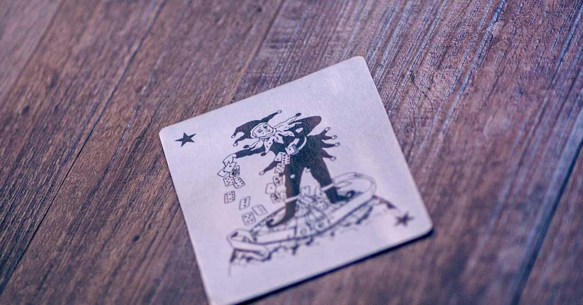 A Joker playing card lies on a textured wooden surface, creating a classic gaming vibe.