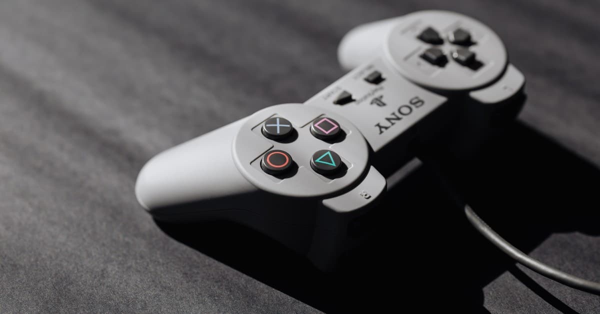 Retro Sony game controller with classic buttons on a textured dark surface, showcasing vintage electronics.
