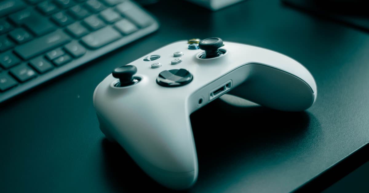 Close-up of a white game controller on a sleek desk, highlighting technology and gaming.