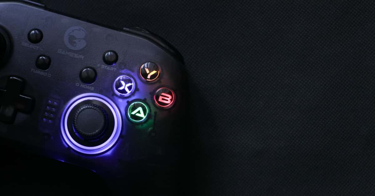 Close-up of a glowing gaming controller against a dark background, highlighting technology and entertainment.