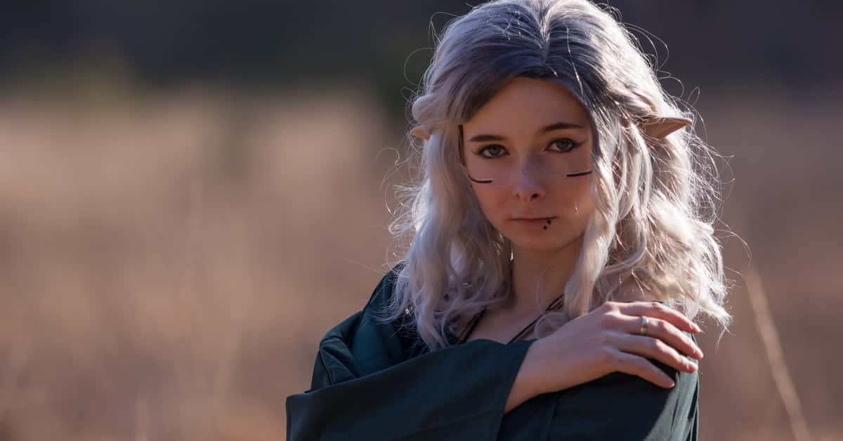 A captivating elf cosplay portrait outdoors with fantasy makeup and ears.
