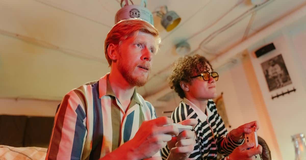 Two men playing video games with controllers and having fun in a cozy room.