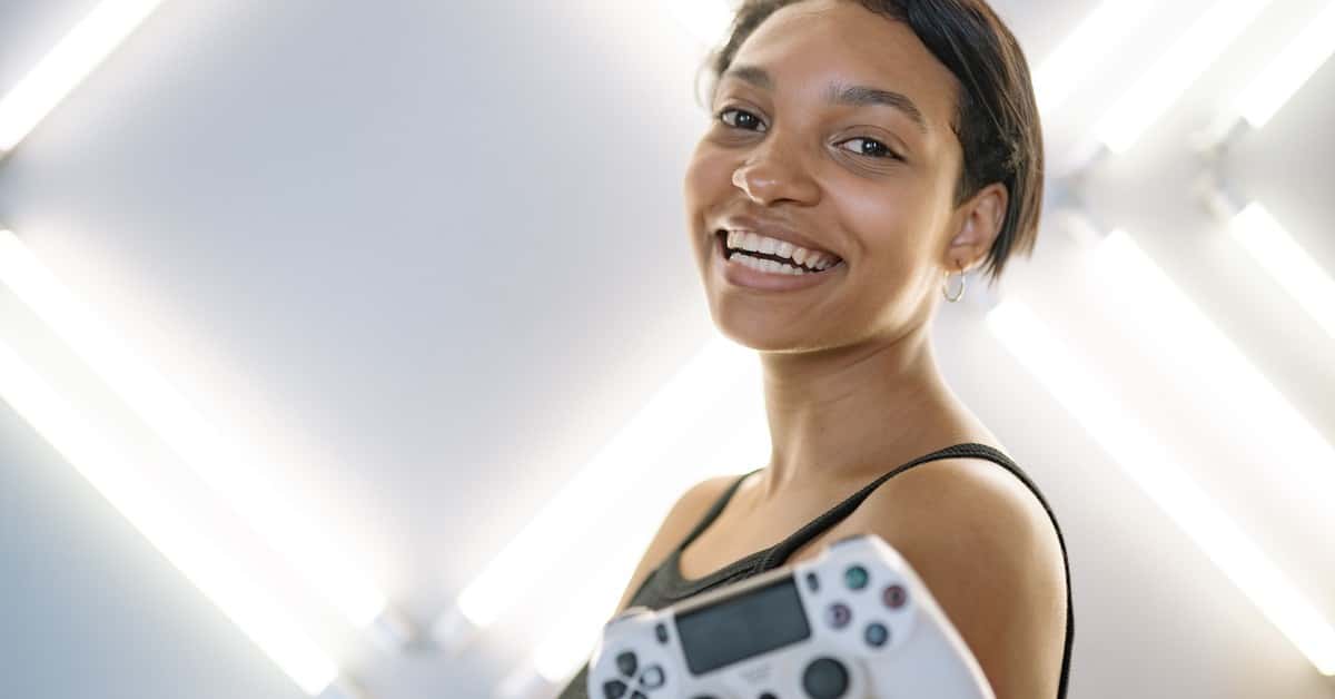 Joyful woman holding a game controller in a modern indoor setting.
