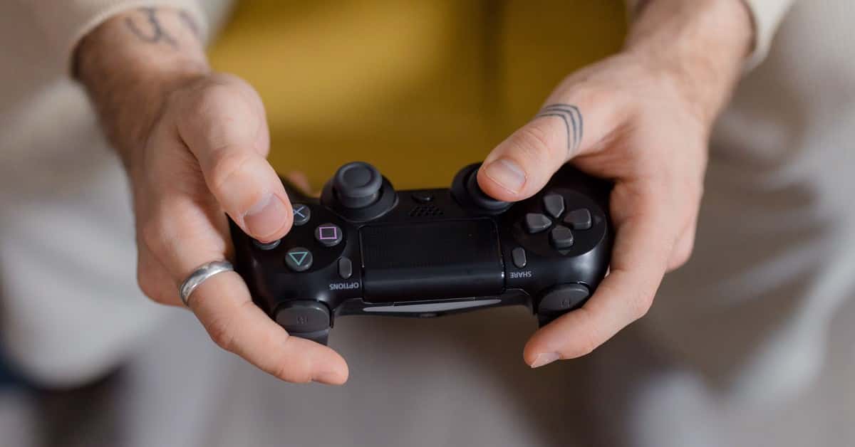 A gamer holding a black game controller, focusing on gaming and entertainment.