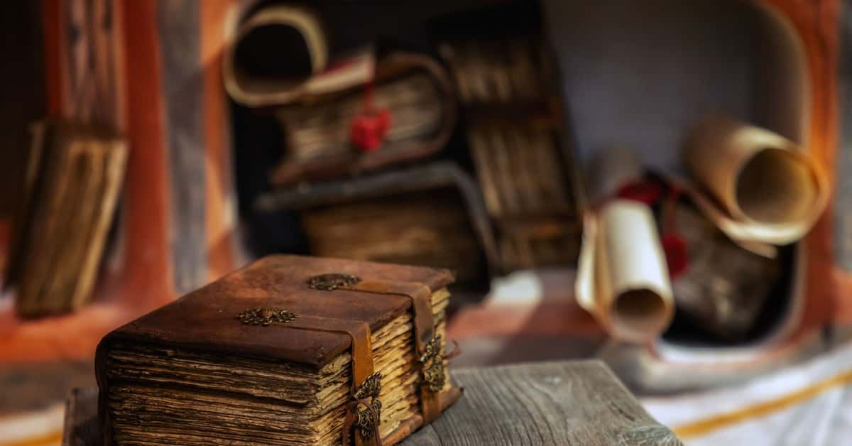 Close-up of a leather-bound antique book on a wooden table, with scrolls in the background, Moscow.