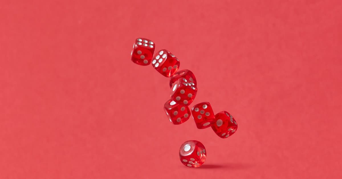 Dynamic shot of red dice tumbling mid-air against a crimson backdrop, perfect for gaming themes.