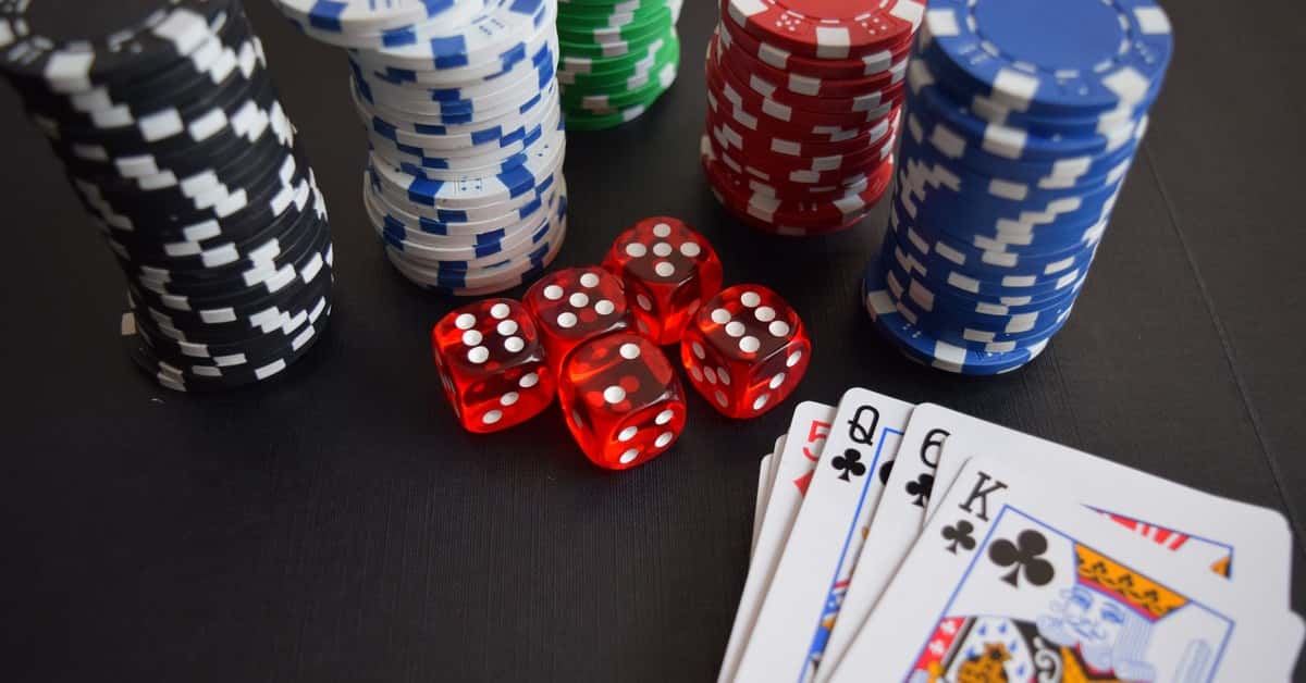 A vibrant display of casino chips, dice, and playing cards set on a table, embodying chance and excitement.