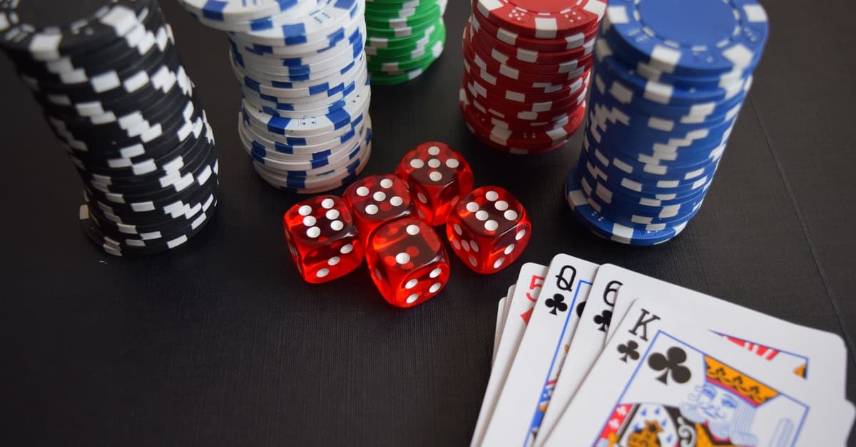 A vibrant display of casino chips, dice, and playing cards set on a table, embodying chance and excitement.