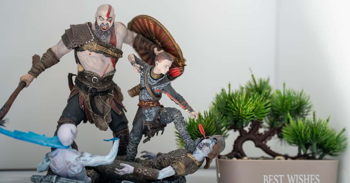 Detailed figurines in an action pose next to a miniature bonsai tree in a pot with 'Best Wishes' text.