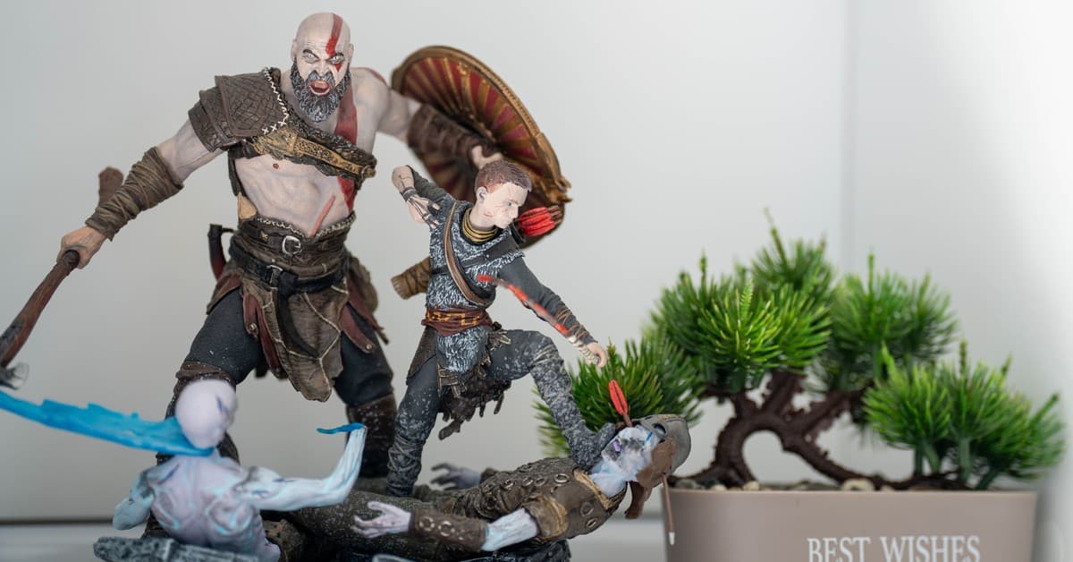 Detailed figurines in an action pose next to a miniature bonsai tree in a pot with 'Best Wishes' text.