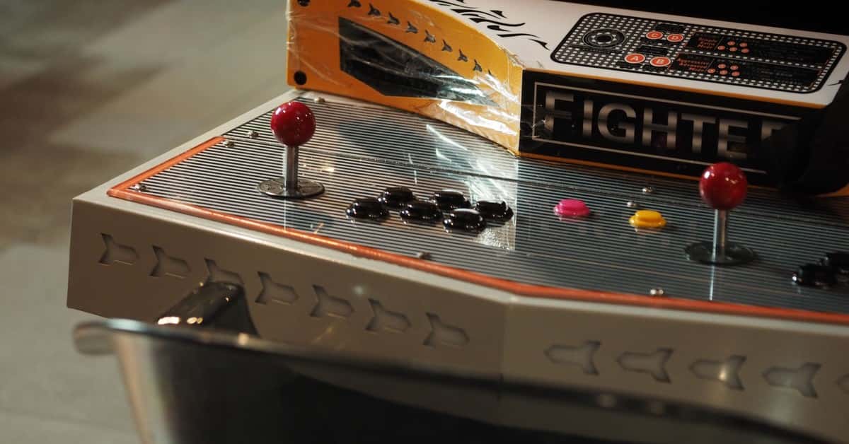 Close-up of a vintage arcade game control panel with joysticks and buttons.