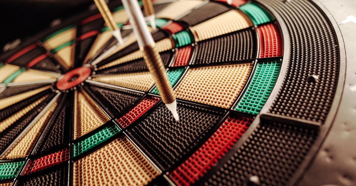 A detailed close-up of an electronic dartboard, showcasing vibrant colors and precision darts hitting the target.