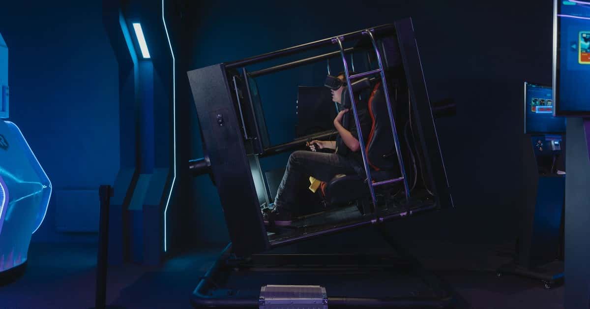 A person using a VR simulator in a high-tech gaming environment.