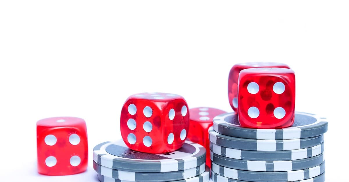 Vibrant red dice stacked with poker chips, ideal for gambling themes.