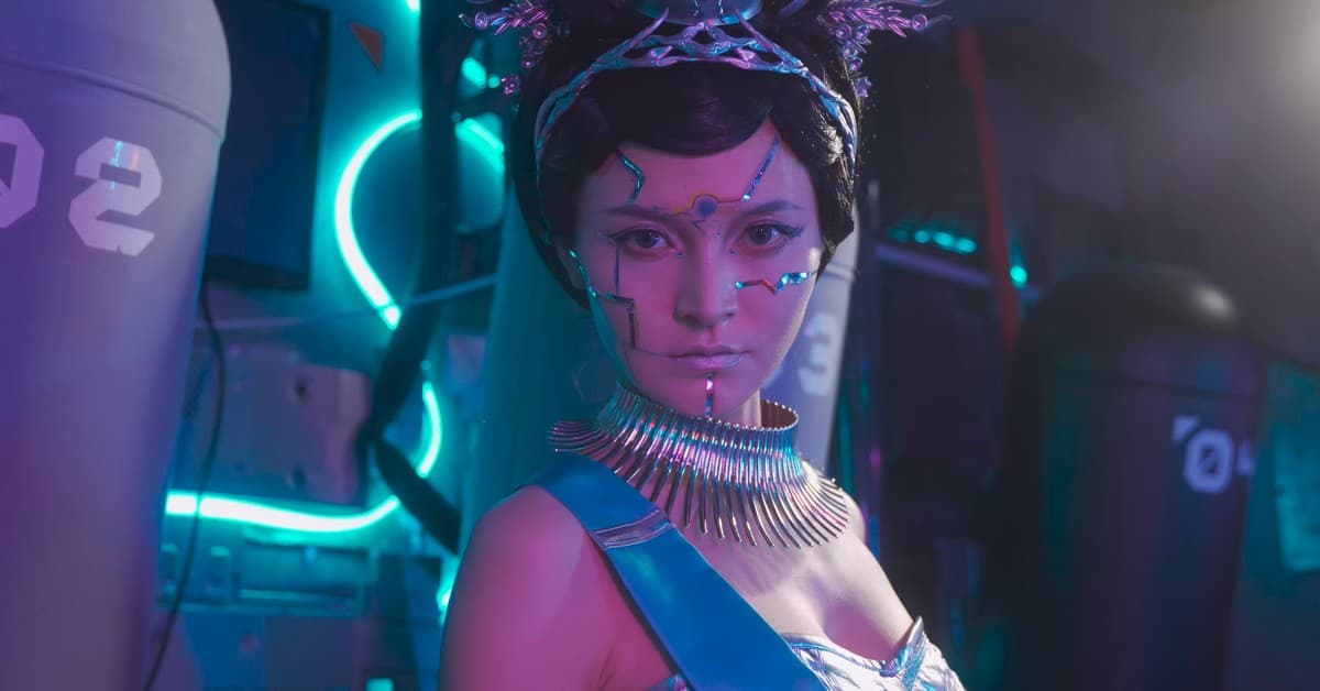 A woman with sci-fi makeup and armor in a vibrant, neon-lit environment.