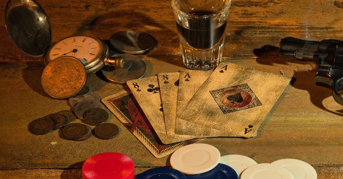 A vintage-themed still life featuring playing cards, poker chips, coins, a revolver, and a pocket watch.