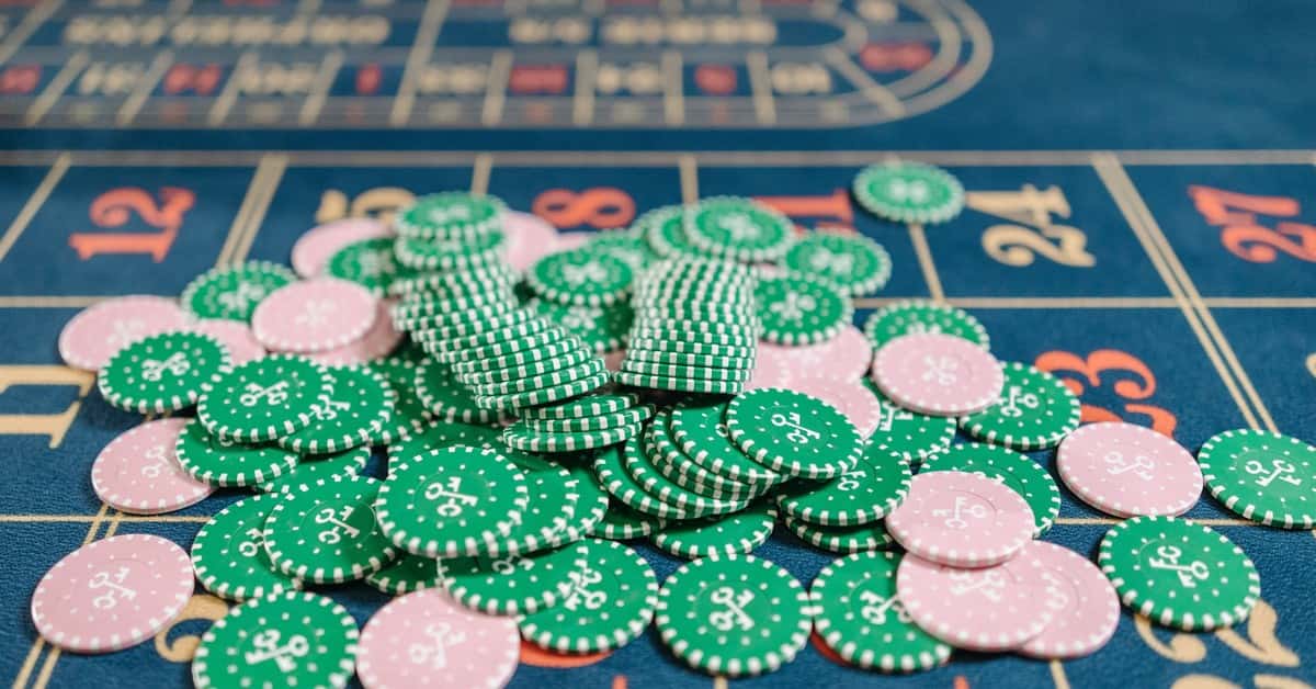 Close-up of a roulette table with a pile of green and pink poker chips.