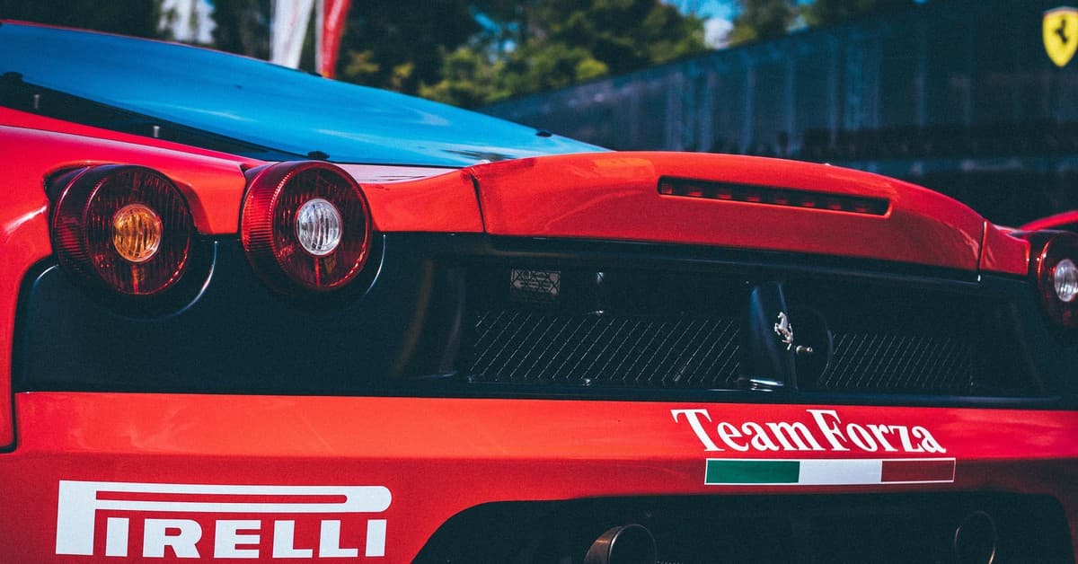 Racing car with Pirelli branding, featuring aerodynamic rear designs. Captured in daylight outdoors.