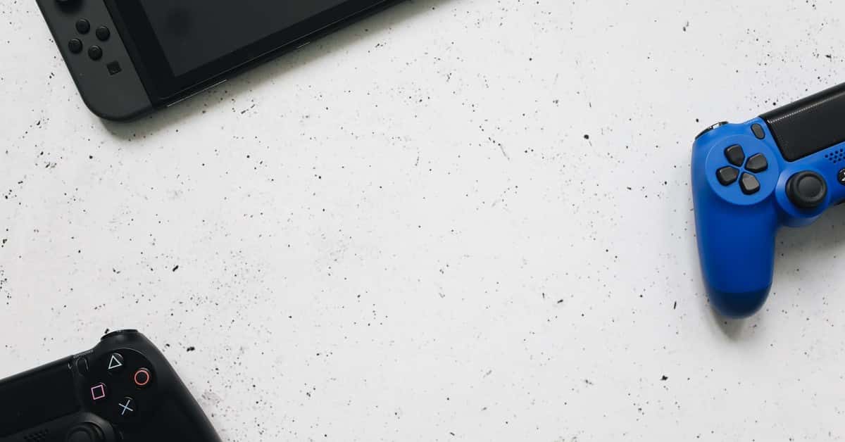 A flat lay of gaming consoles and controllers on a white surface, ideal for tech enthusiasts.