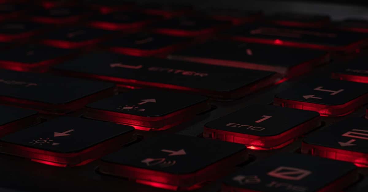 Detailed view of a backlit gaming keyboard with red LED lighting and black keys.