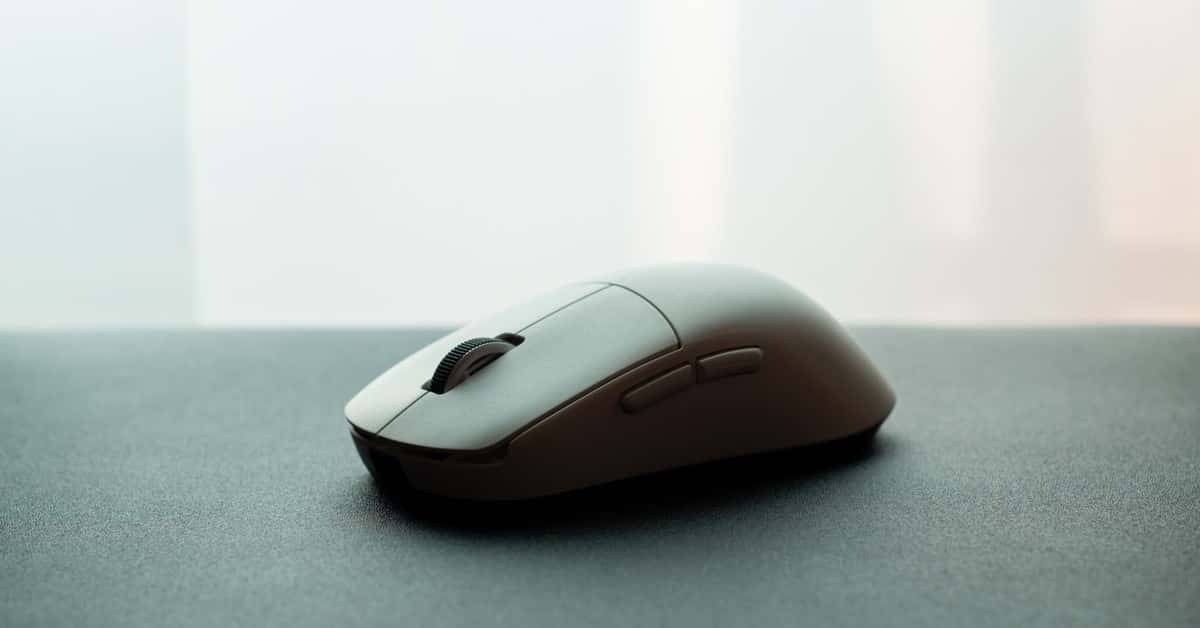 Close-up of a white wireless computer mouse on a dark surface, emphasizing sleek design.