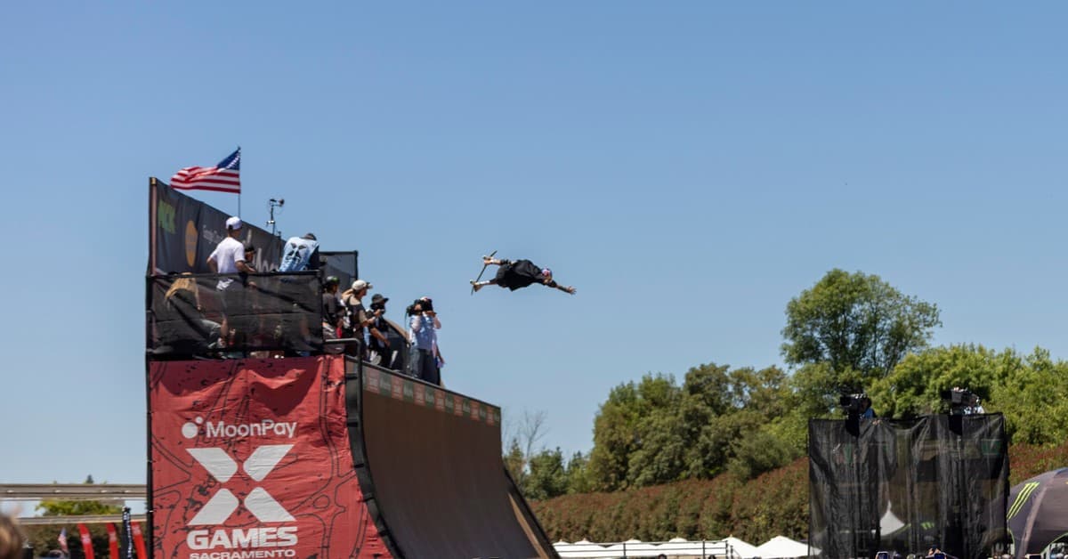 Exciting skateboard stunt at X Games 2026 in Sacramento, captured mid-air with crowd spectators.