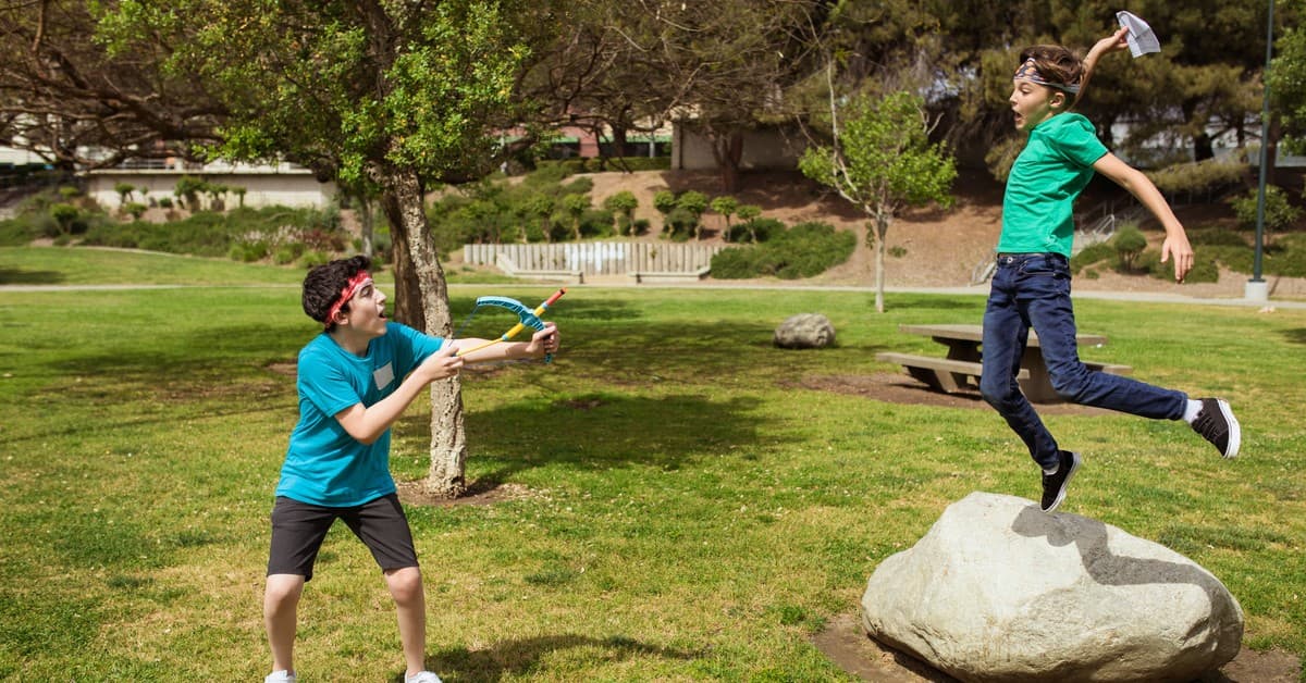 Two boys having fun and playing games outdoors during summer camp.