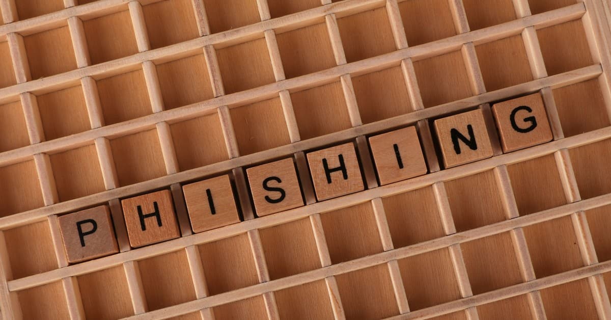 Wooden Scrabble tiles arranged to spell 'Phishing', illustrating online security concepts.