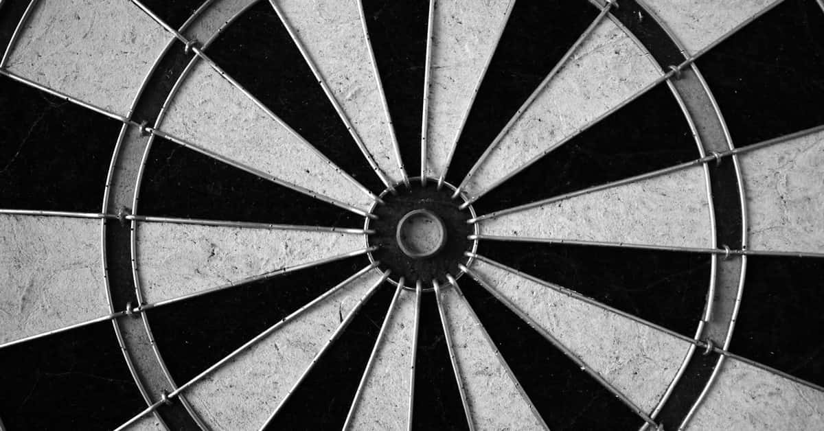 Monochrome image of a dartboard showcasing its geometric patterns in detail.