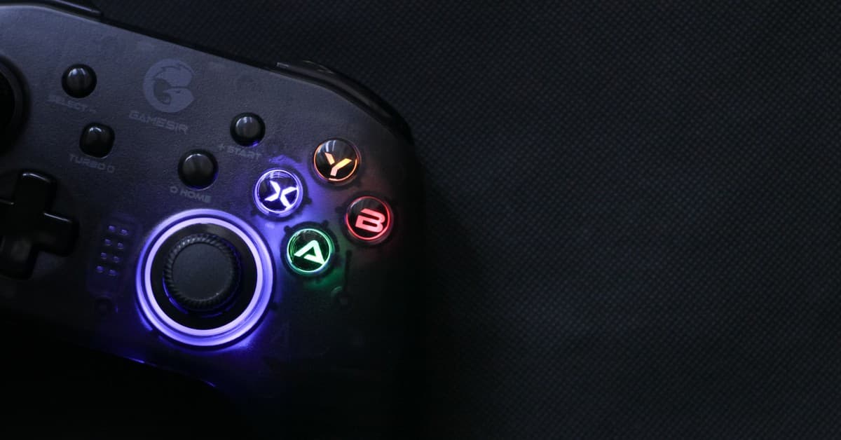 Close-up of a glowing gaming controller against a dark background, highlighting technology and entertainment.