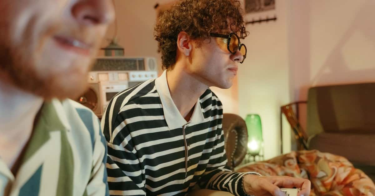 Two young men enjoying video games in a retro-themed room, capturing a nostalgic and fun atmosphere.