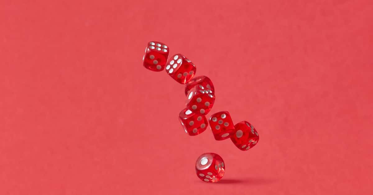 Dynamic shot of red dice tumbling mid-air against a crimson backdrop, perfect for gaming themes.